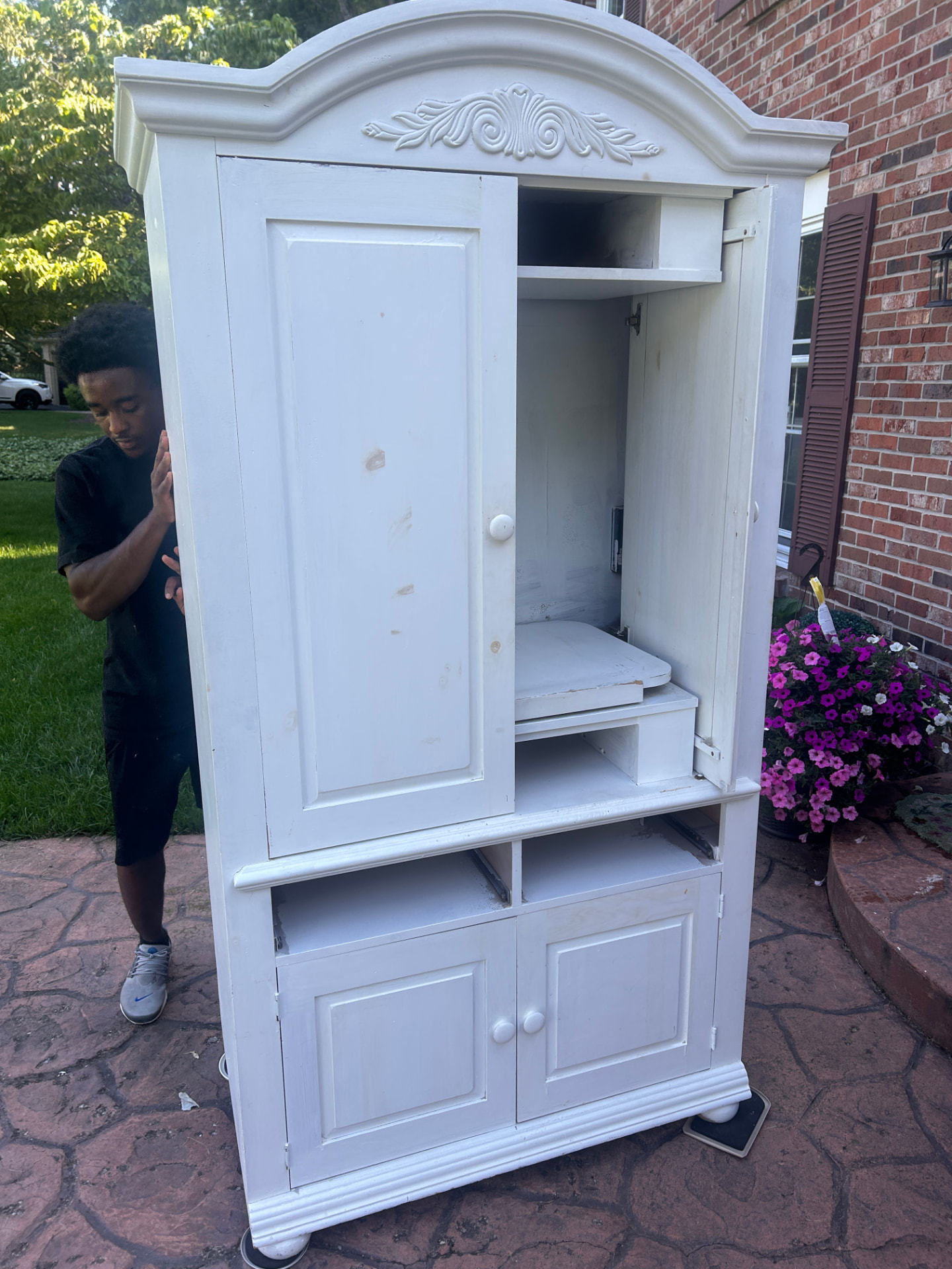 Crew member hauling an armoire out of a home